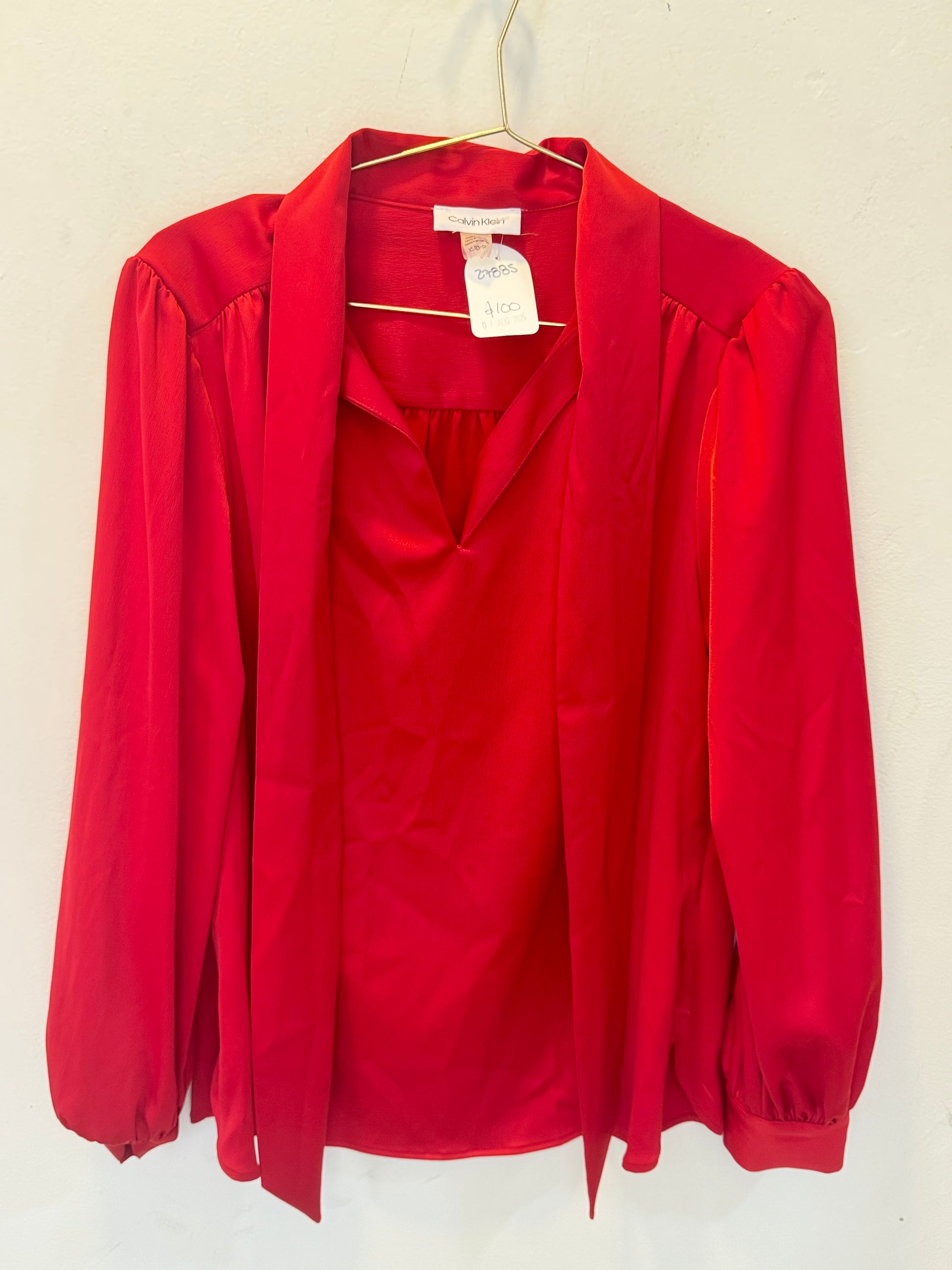 Blusa satinada con lazo rojo